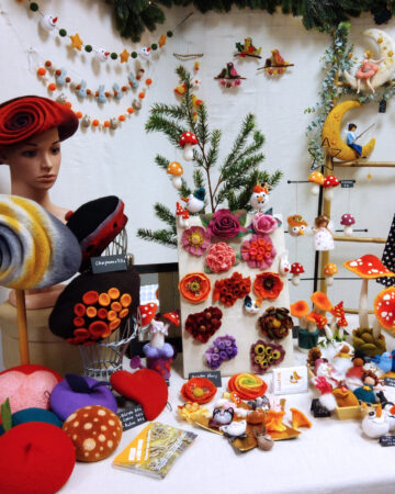 Créations d'IssaFelt en laine feutrée lors de la boutique éphémère. Bérets et chapeaux pour femmes, fleurs, champignons et autres accessoires de décoration.