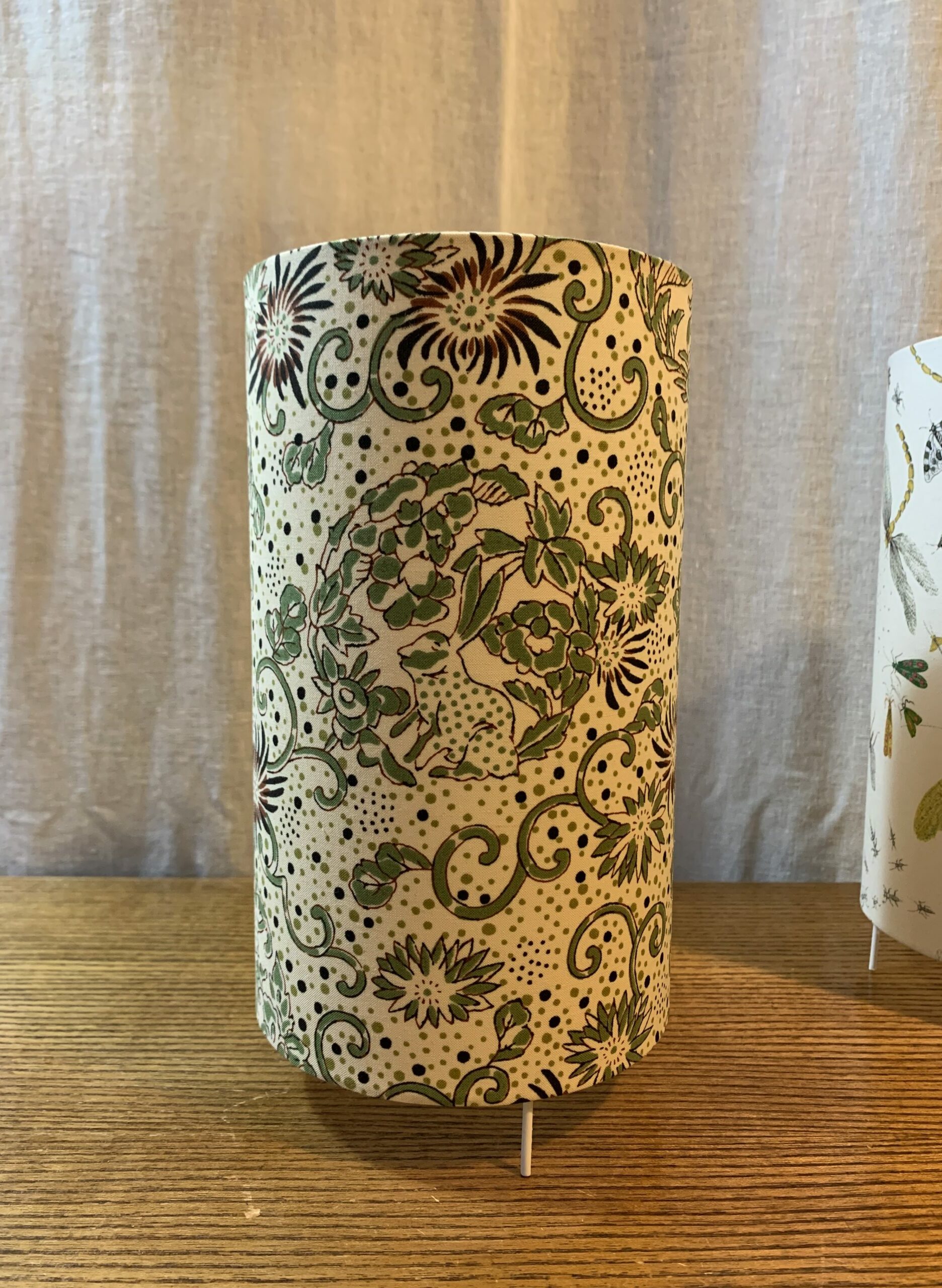 De forme cylindrique, lampe à poser réalisée par Sara Marquet, dans un tissu de percale représentant un lapin dont le dessin est inspiré du design d’un paravent japonais