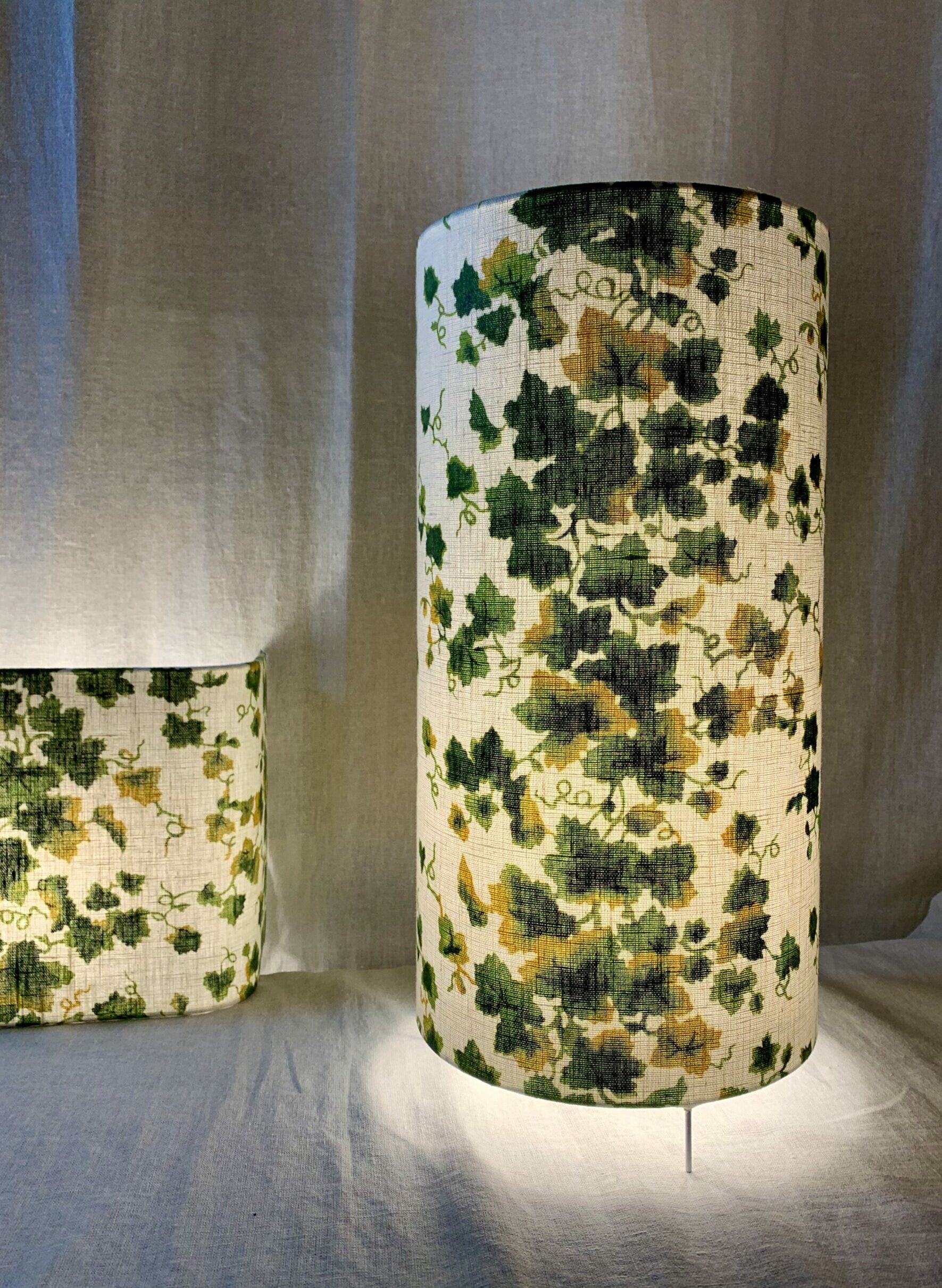 Lampe à poser de forme haute et cylindrique réalisée par Sara Marquet, habillée d'un tissu représentant un lierre grimpant, image joyeuse faisant entrer le végétal dans la maison.