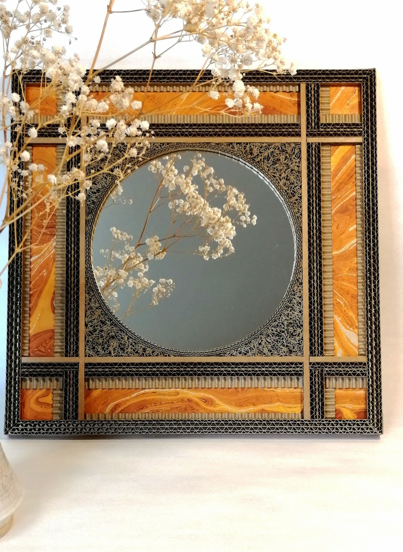 JEMA 2024-autour du carton-miroir orange : miroir rond encadré par une décoration de dentelle de carton et de papier marbré orange.