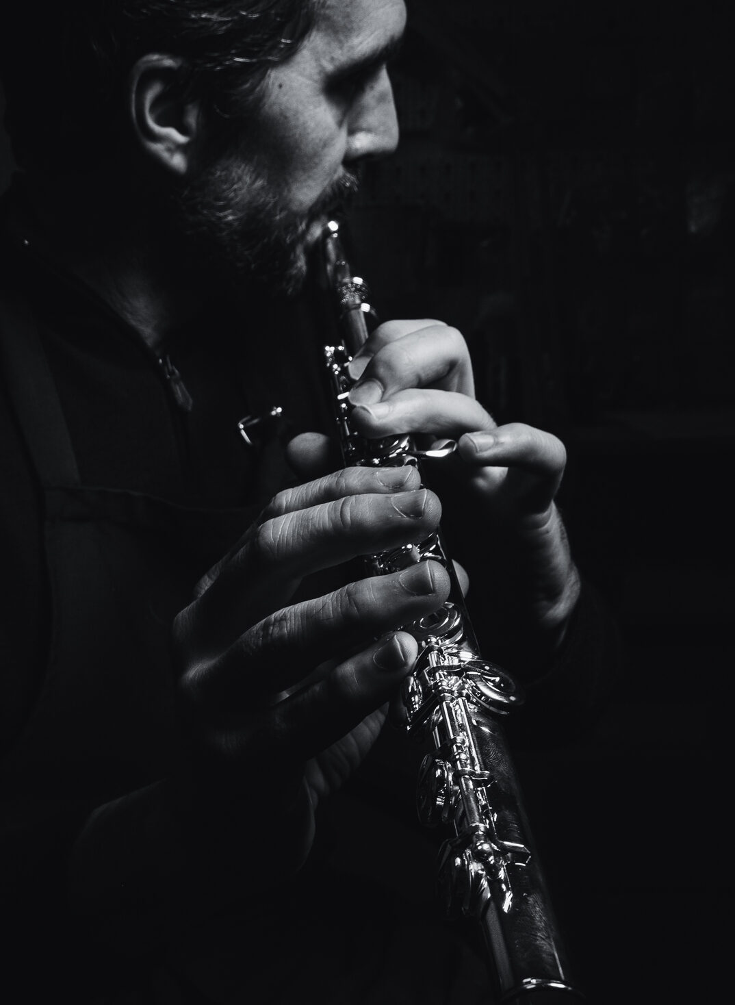Geoffrey Gekiere joue de la flute traversière. photo en noir et blanc Atelier Contrechant