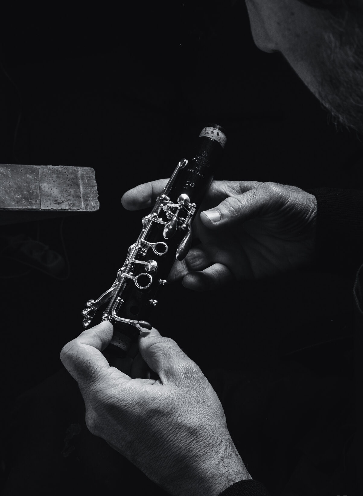 Geoffrey Gekiere travaillent sur un élément de clarinette. photo en noir et blanc Atelier Contrechant