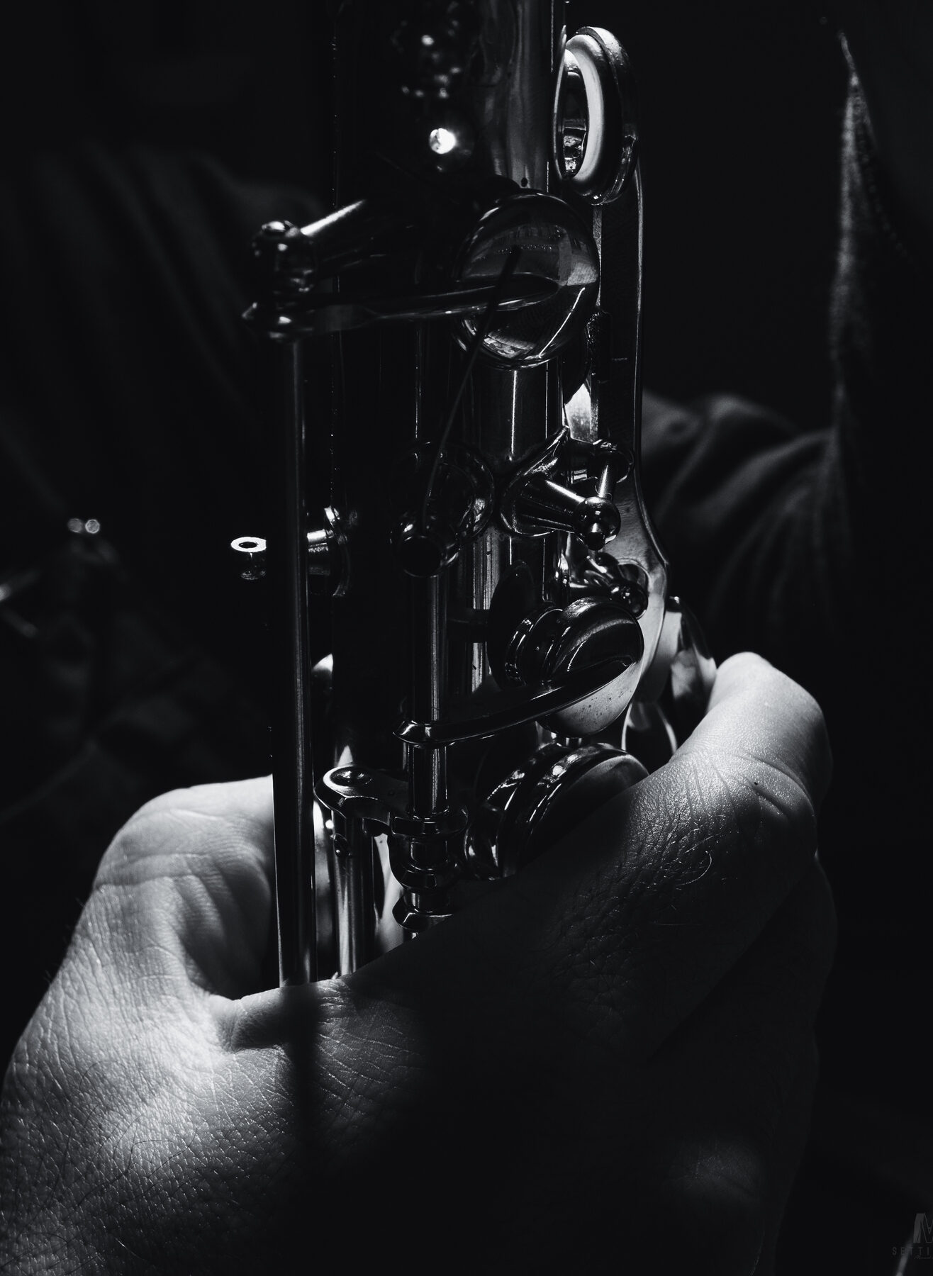 Geoffrey Gekiere travaille sur un saxophone. photo en noir et blanc Atelier Contrechant