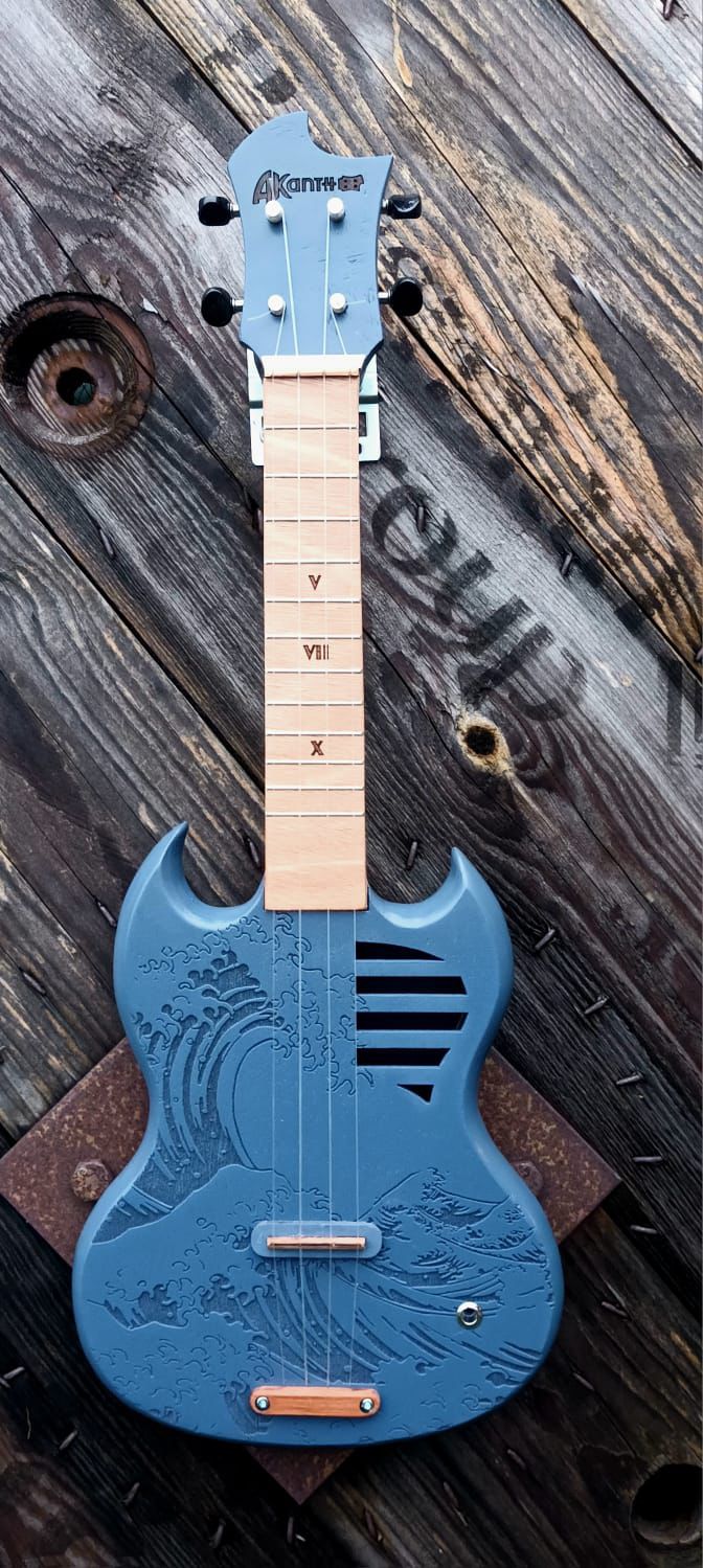 Angus vague bleue-ukulélé Akanth accoustique en forme de guitare électrique (Sg) avec un motif inspiré de hokusaî.