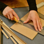 artisan d'art, Autour du Carton, les mains au travail coupant du carton. atelier Autour du Carton de Véronique Tulasne